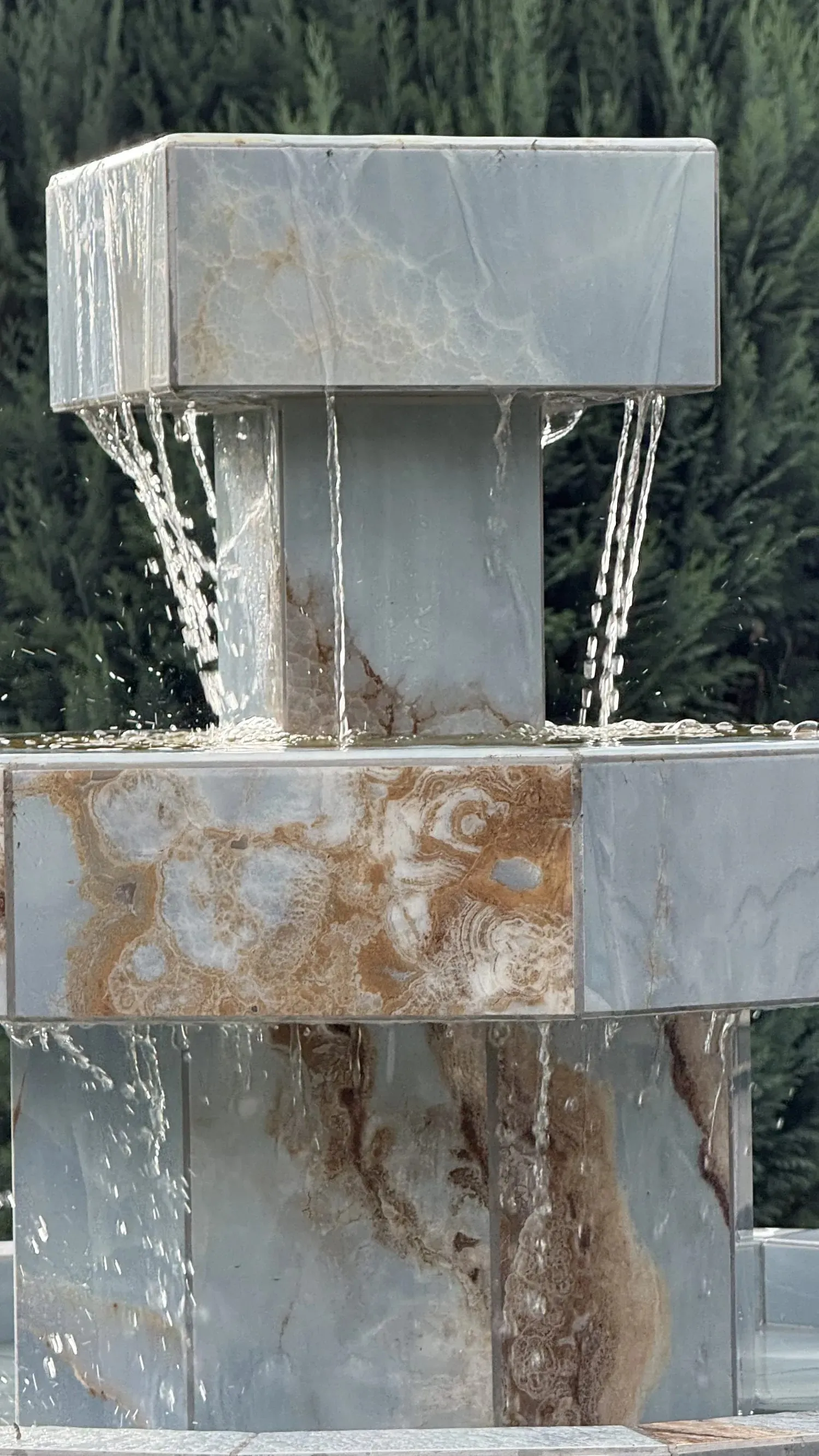 Der Brunnen in Betrieb: Wasser läuft vom quadratischen Kopf über die Etagen nach unten